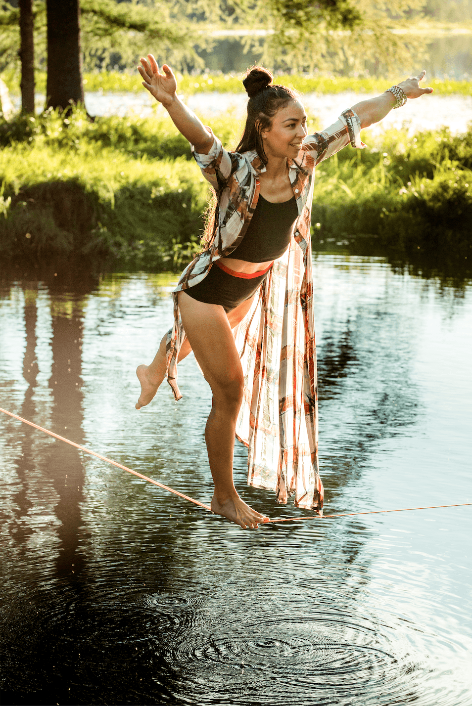 Femme qui marche en équilibre au dessus d'une rivière en culotte menstruelle. 