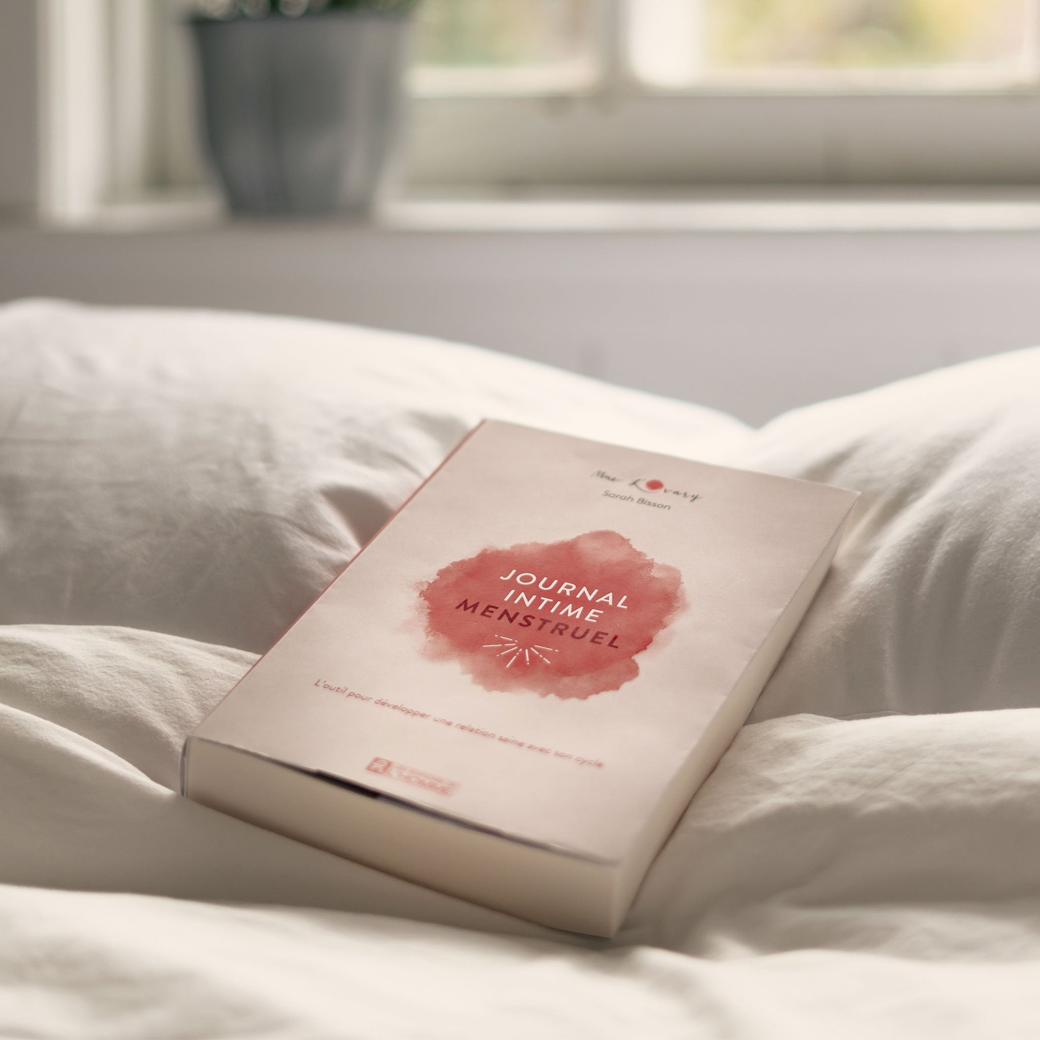 Journal pour comprendre son cycle menstruel posé sur un lit